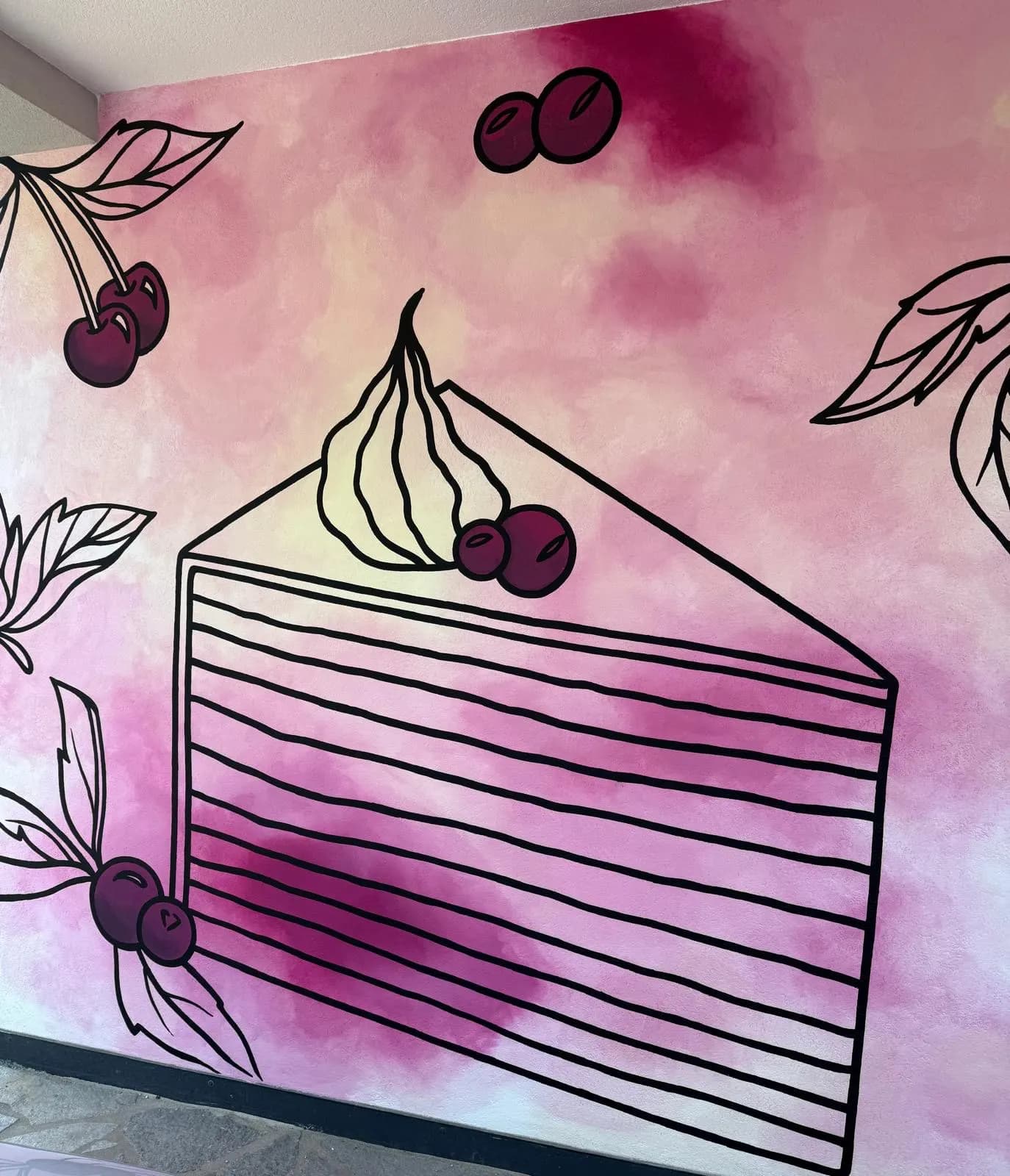 Wandbild mit einem gemalten Tortenstück und Kirschen auf Rosa
