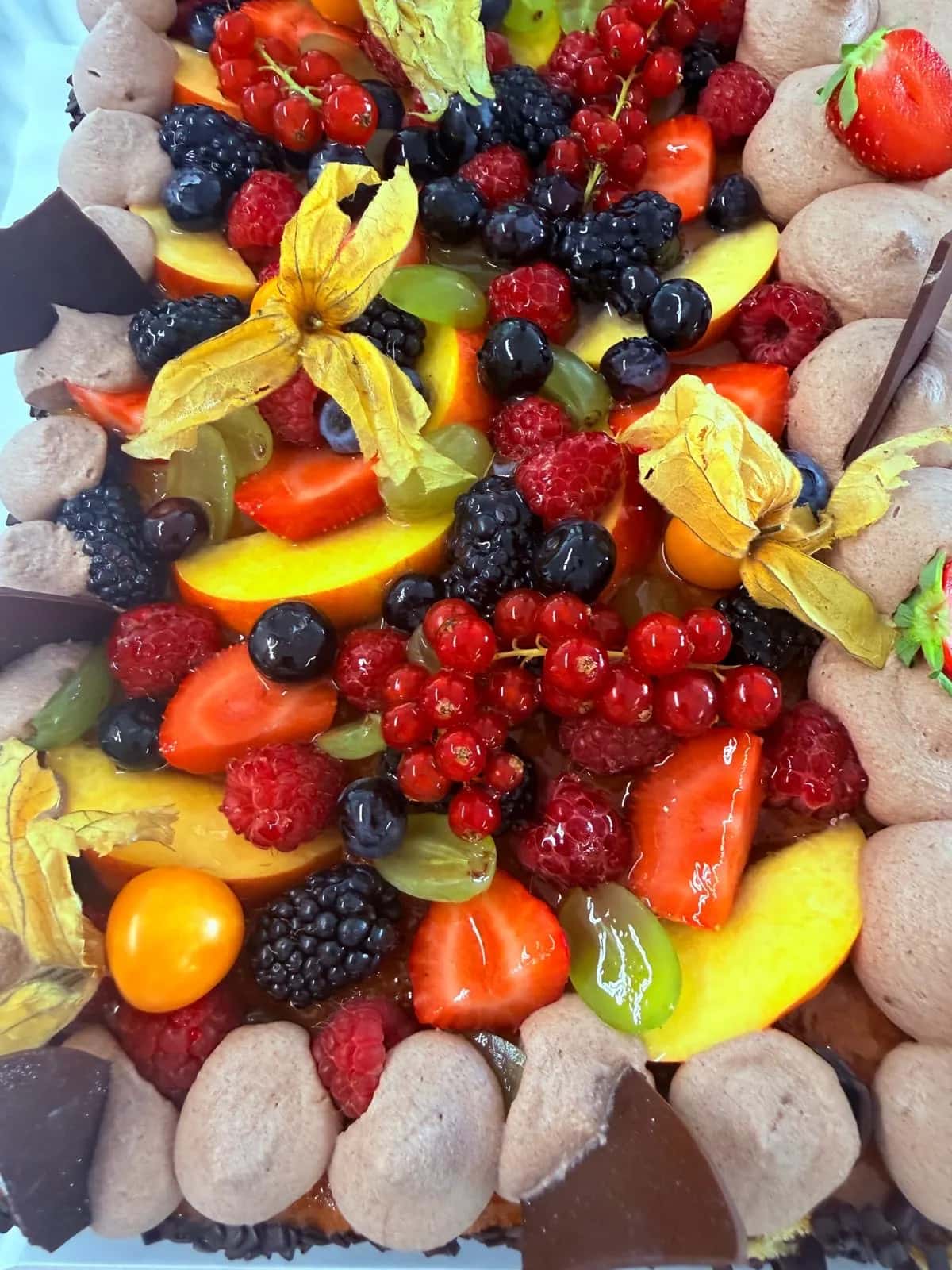 Torte mit einem dichten Belag aus frischen Beeren und Früchten